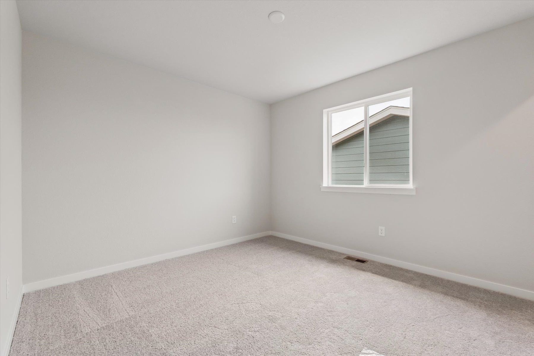 A room with a window and a carpet.