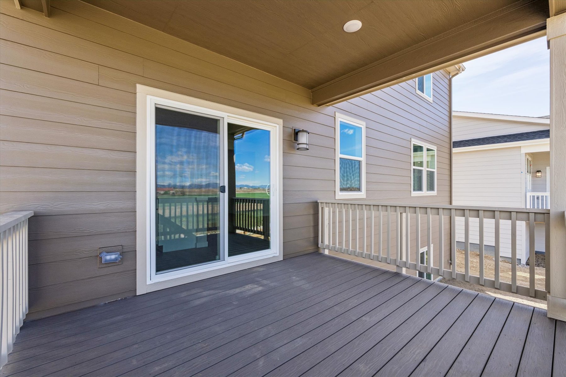 A deck with a wood deck and a white railing and a wood deck.