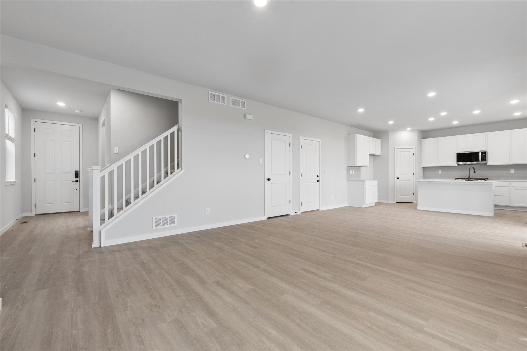 A room with white walls and wood floors.