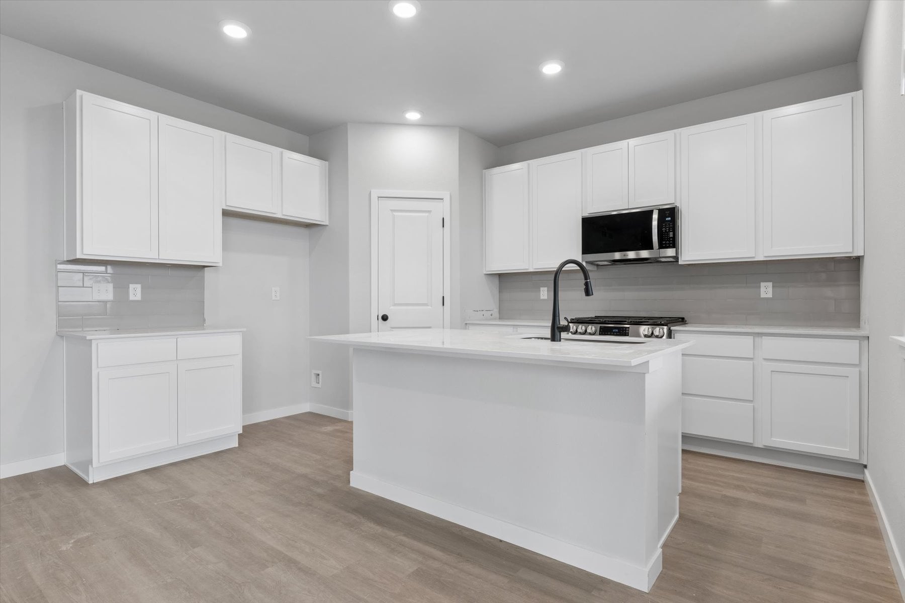 A kitchen with white cabinets.