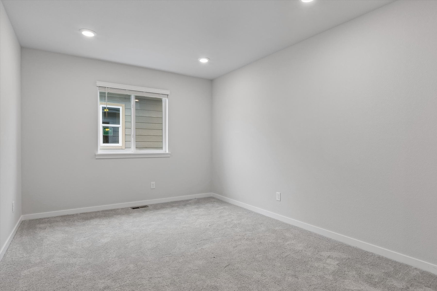 A room with a window and a carpet.