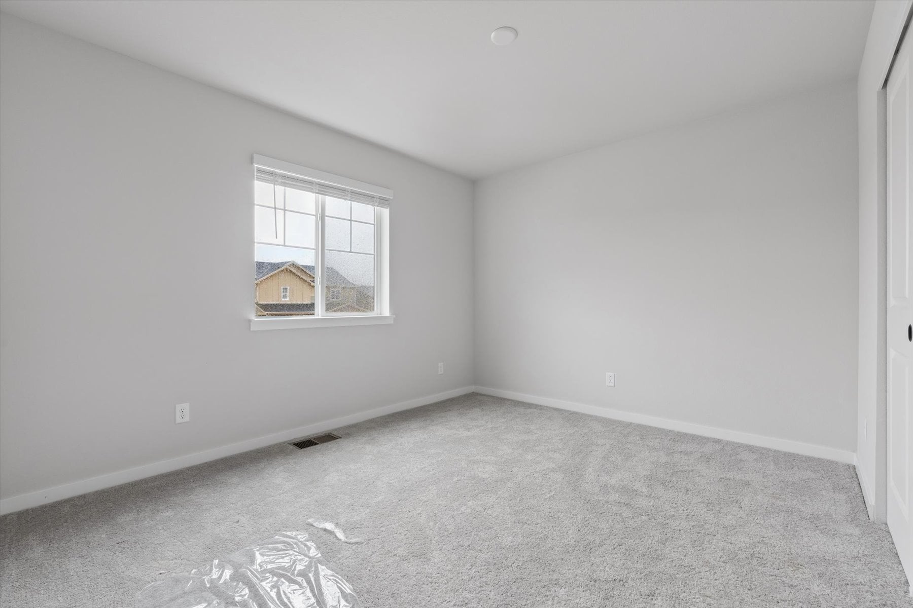A room with a window and carpet.