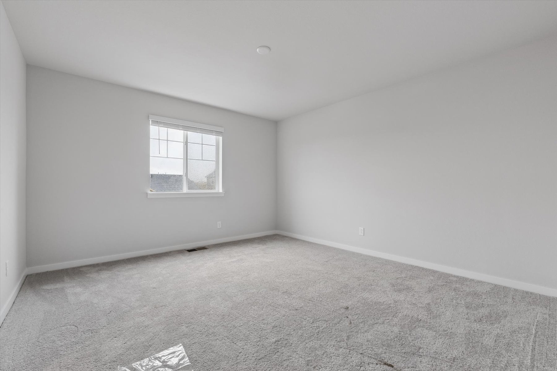 A room with a window and carpet.