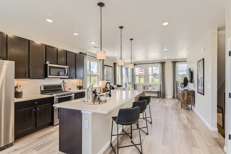 A kitchen with a bar and chairs.
