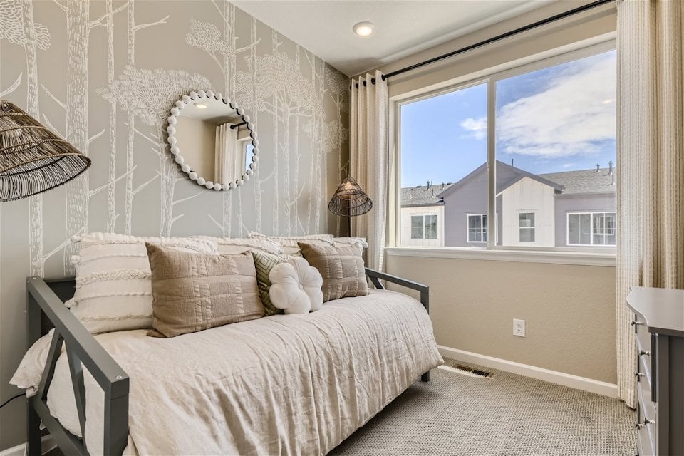 A bedroom with a large window.