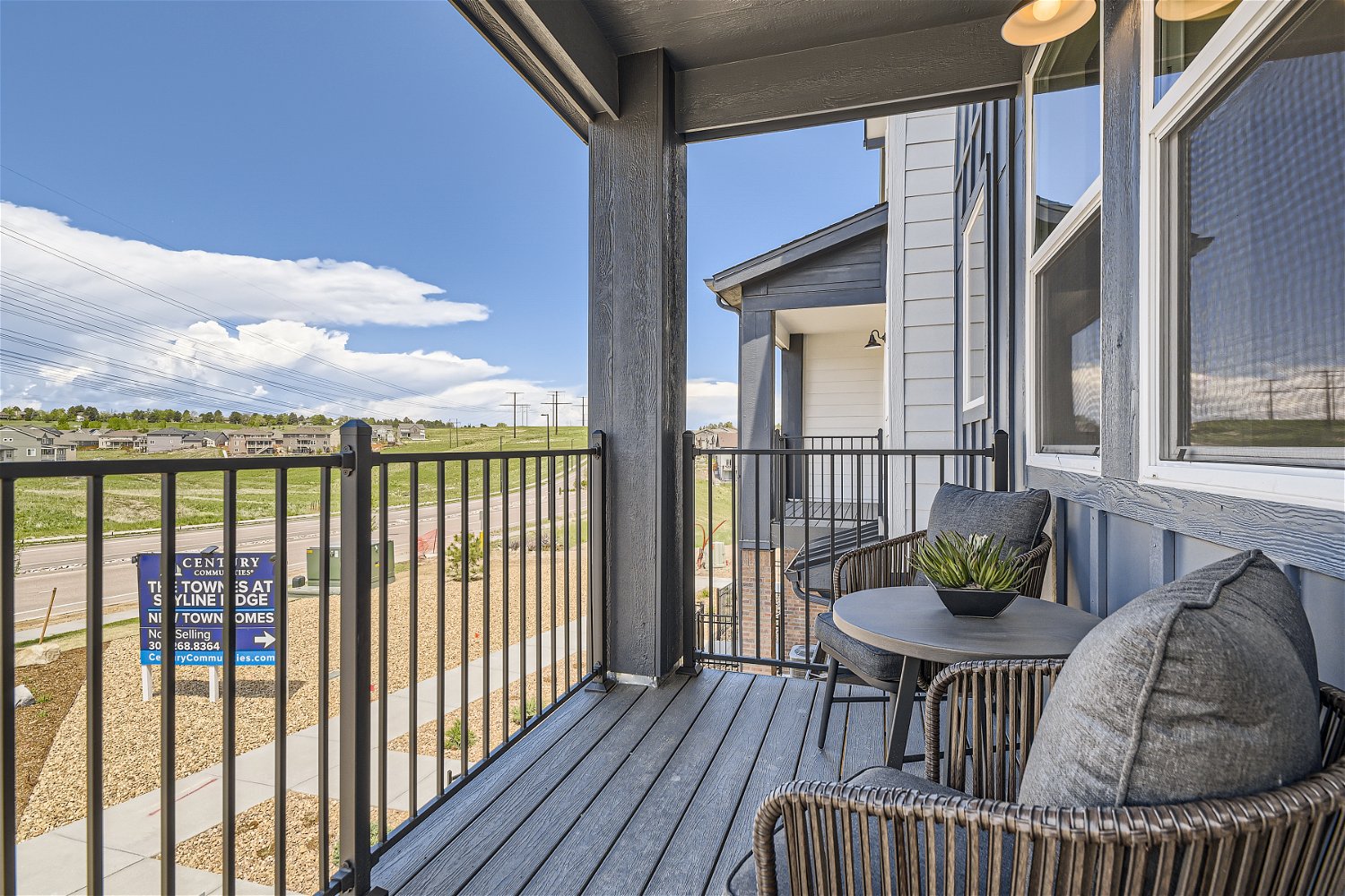 A deck with a table and chairs on it and a view of the mountains and the ocean.