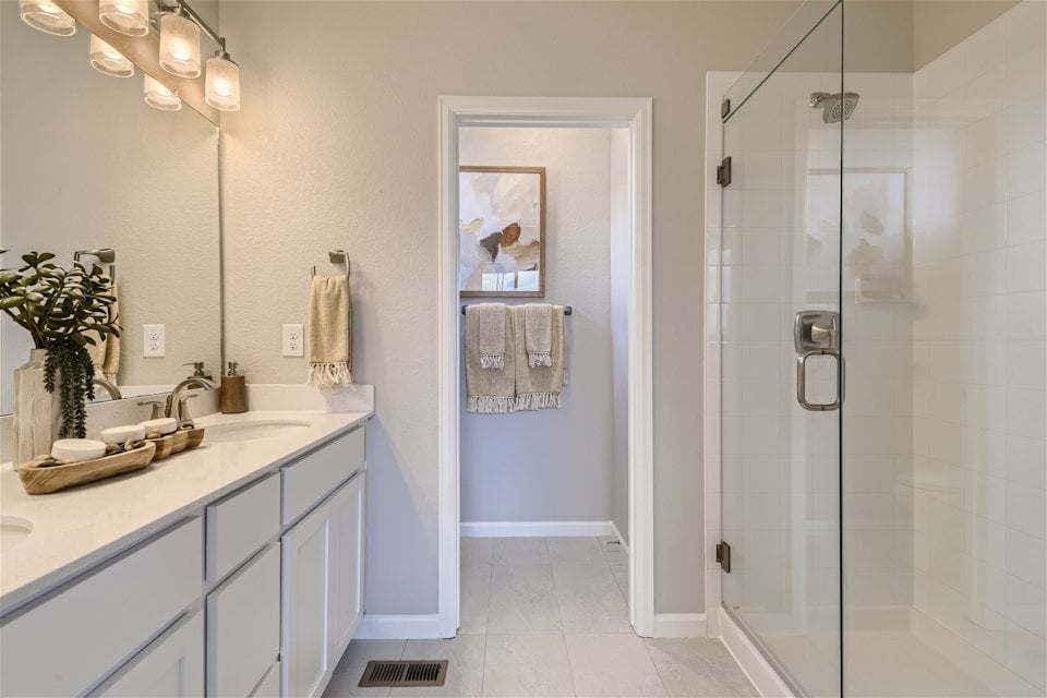 A bathroom with a shower unit and a sink.