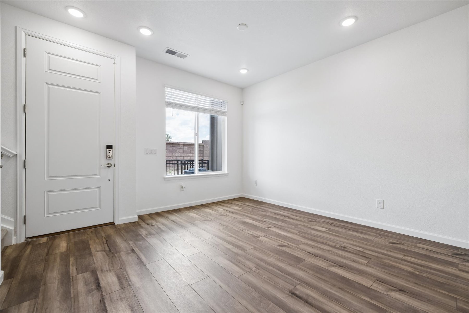 A room with a wood floor and a window with a wood floor.
