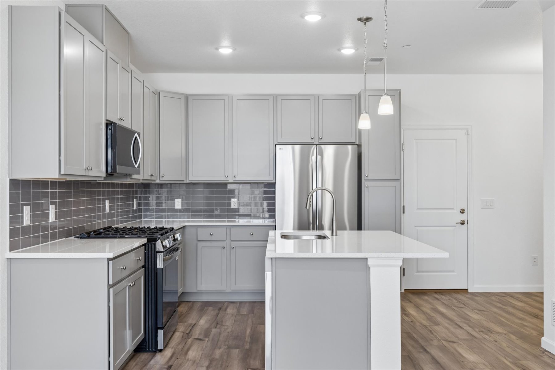 A kitchen with white cabinets.