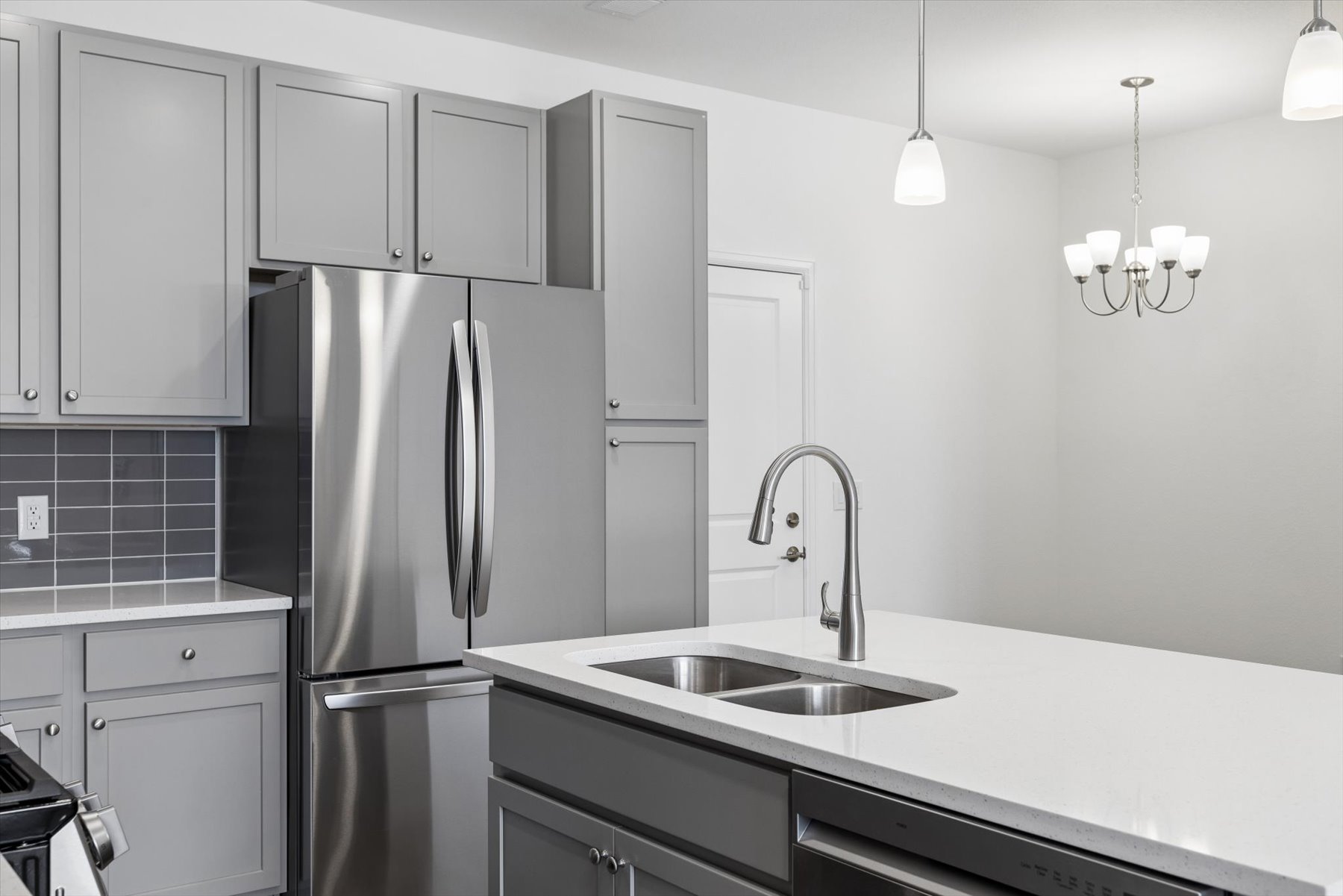A kitchen with white cabinets.