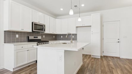 A kitchen with white cabinets.