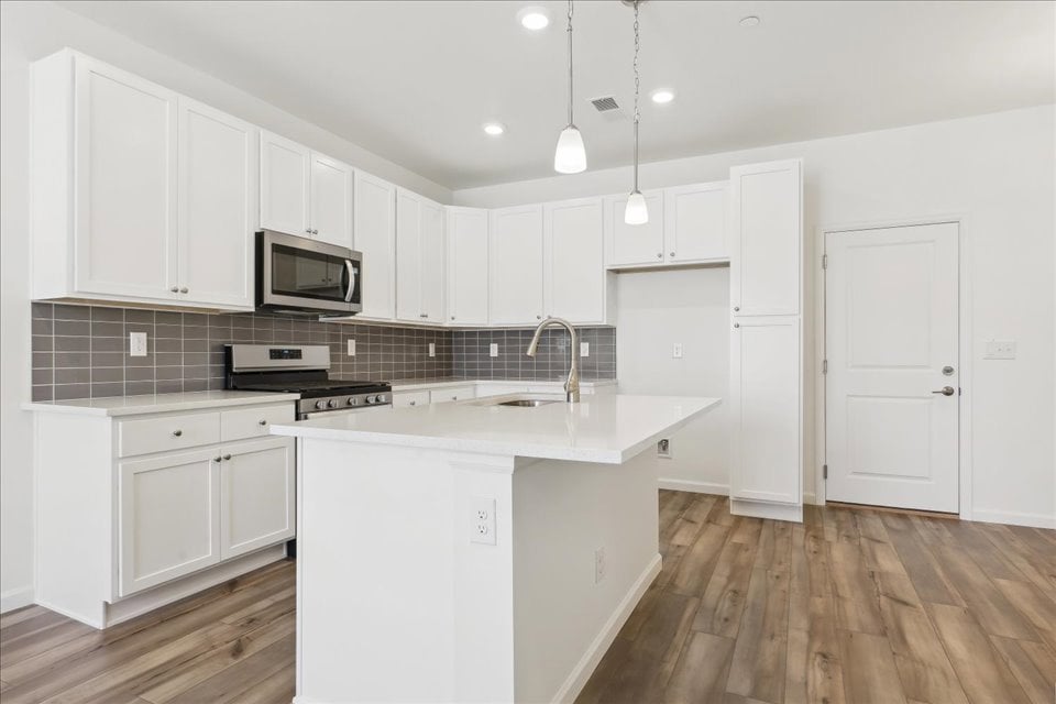 A kitchen with white cabinets.