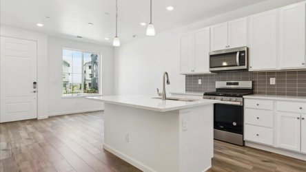 A kitchen with white cabinets.