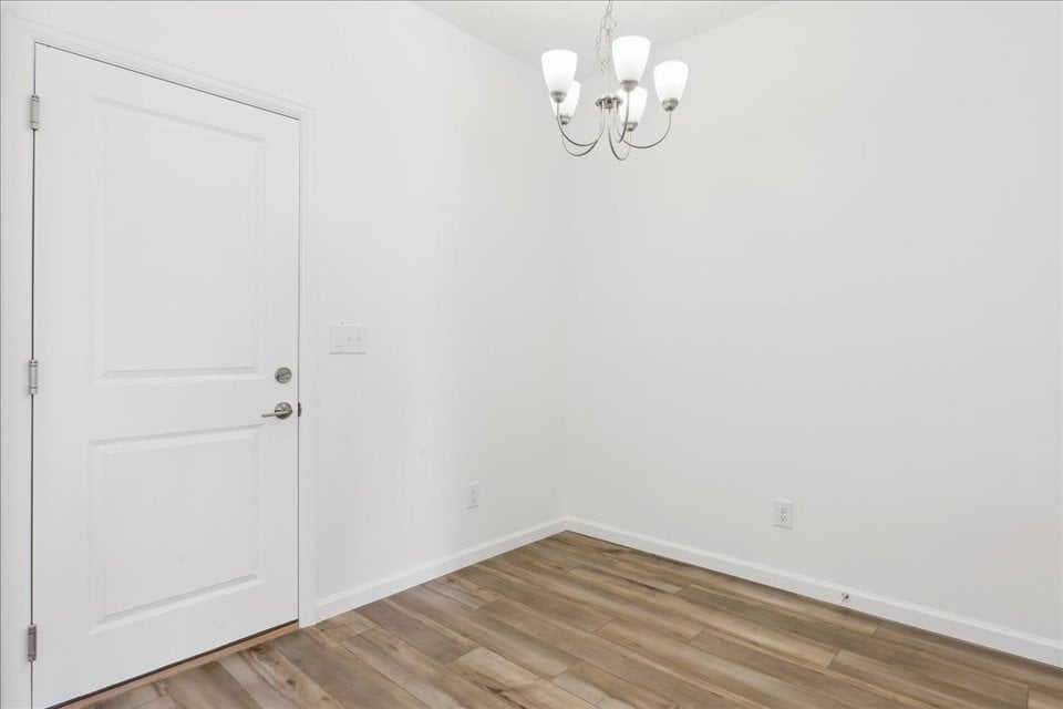 A room with a white door and white walls.