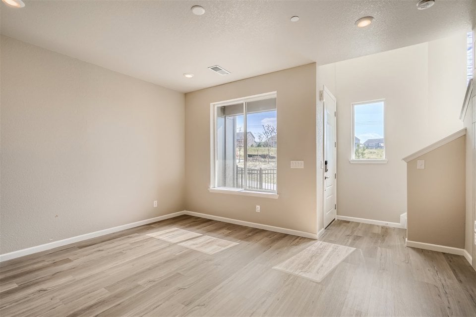 A room with a wood floor and a window.