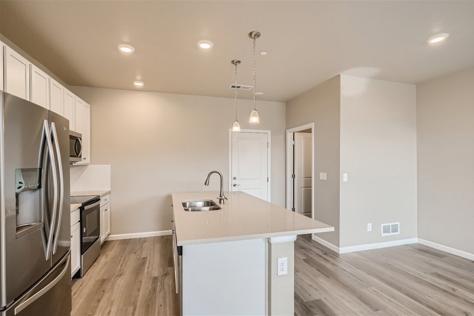 A kitchen with white cabinets.