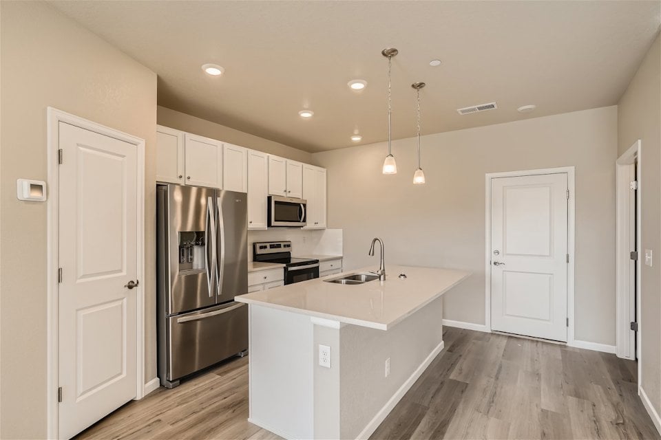 A kitchen with white cabinets.