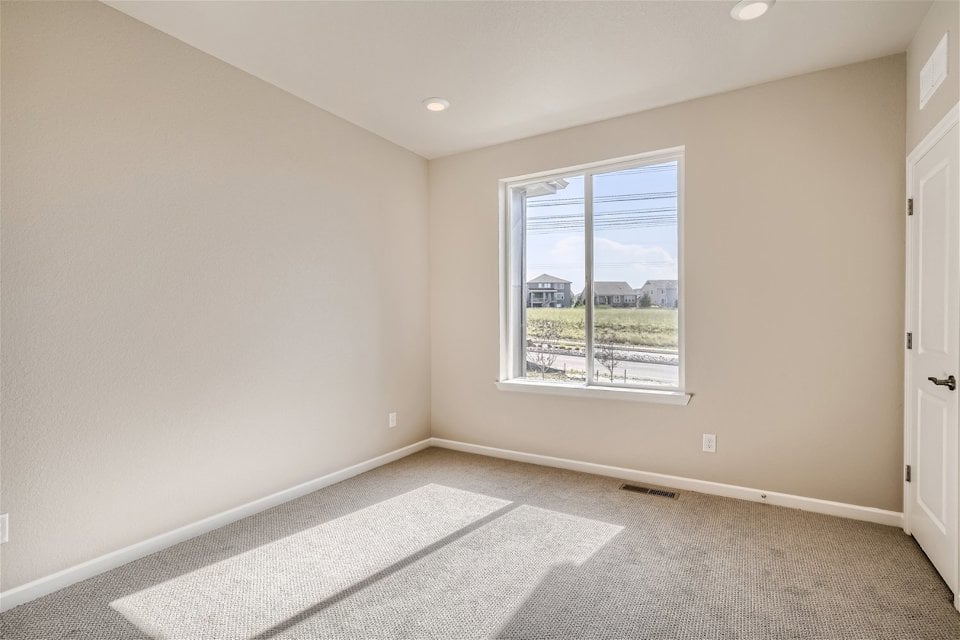 A room with a window and a rug.
