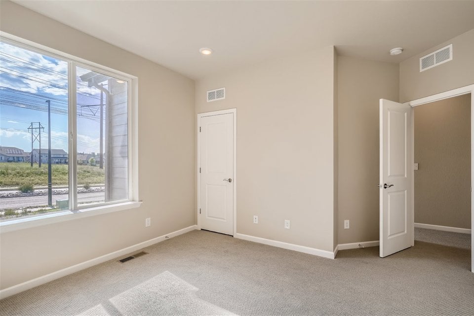 A room with a window and a door with a view of the city.