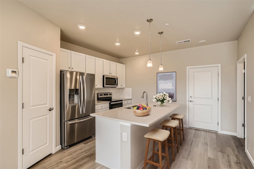 A kitchen with white cabinets.