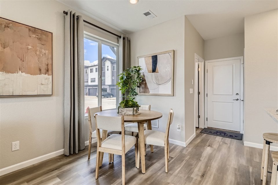 A dining room with a table and chairs.