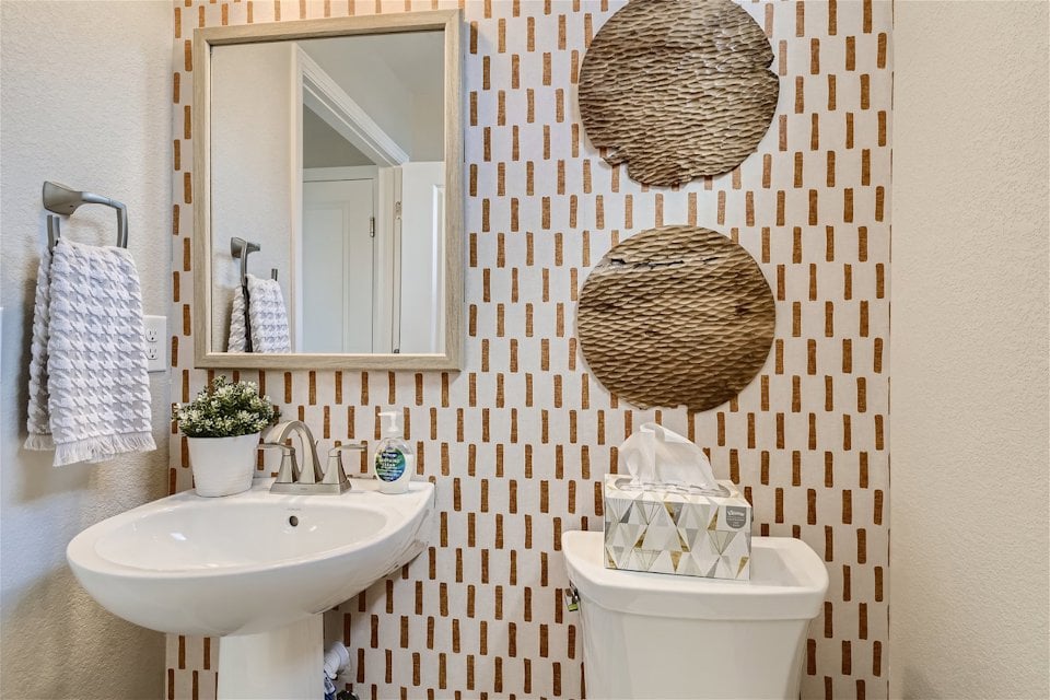 A bathroom with a mirror and a sink.