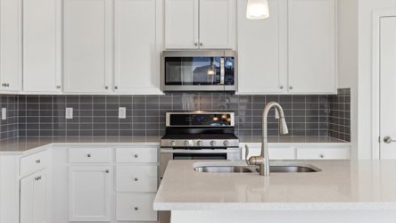 A kitchen with white cabinets.