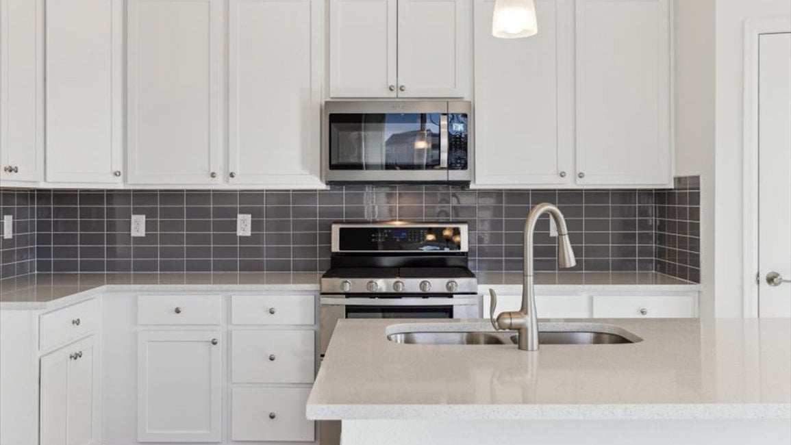 A kitchen with white cabinets.