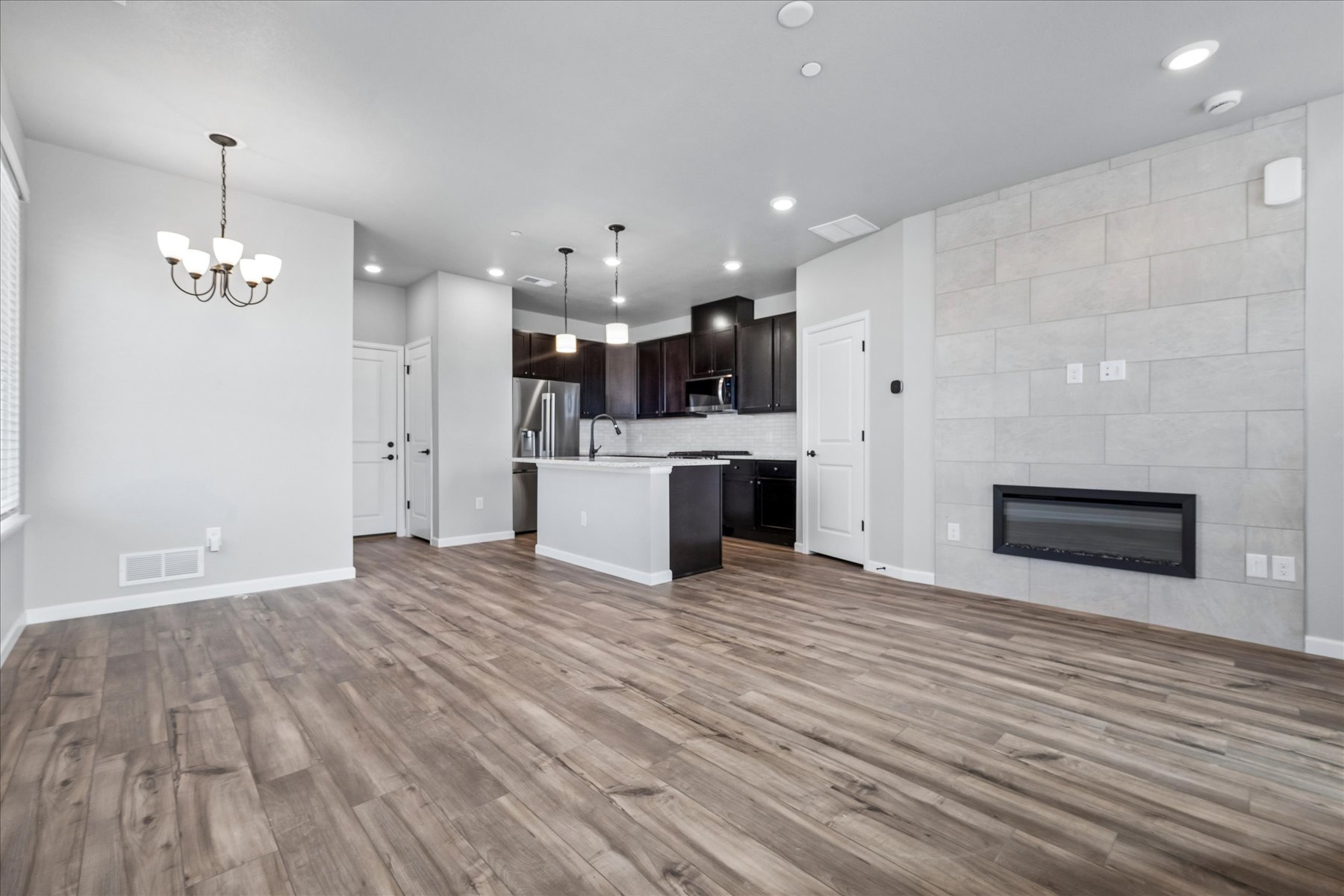 A large kitchen with a wood floor.