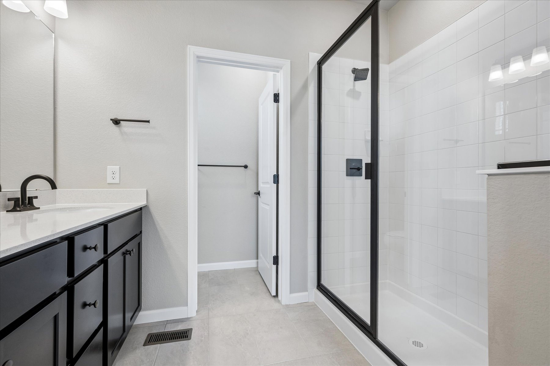 A bathroom with a shower unit and sink.