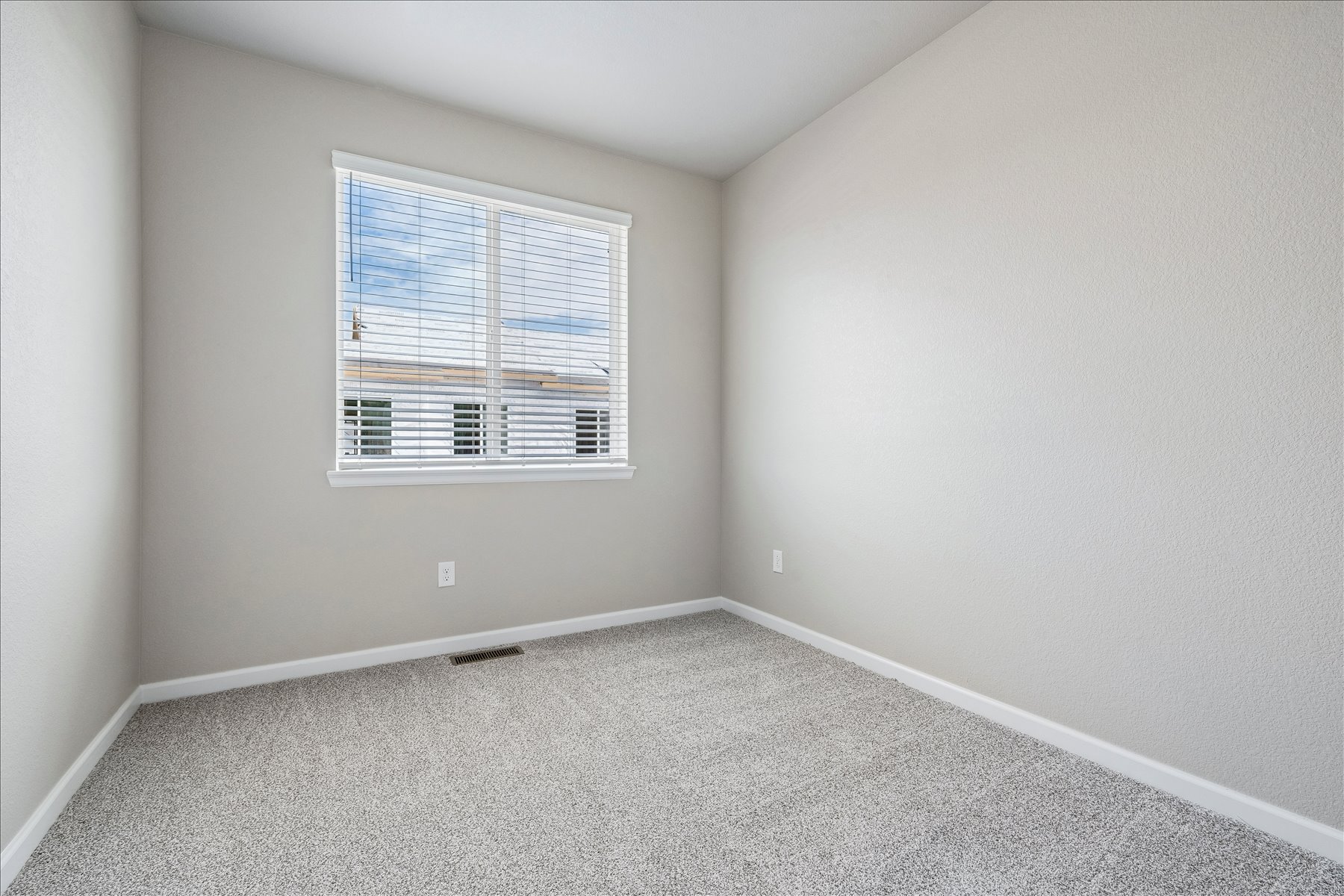 A room with a window and a carpet.