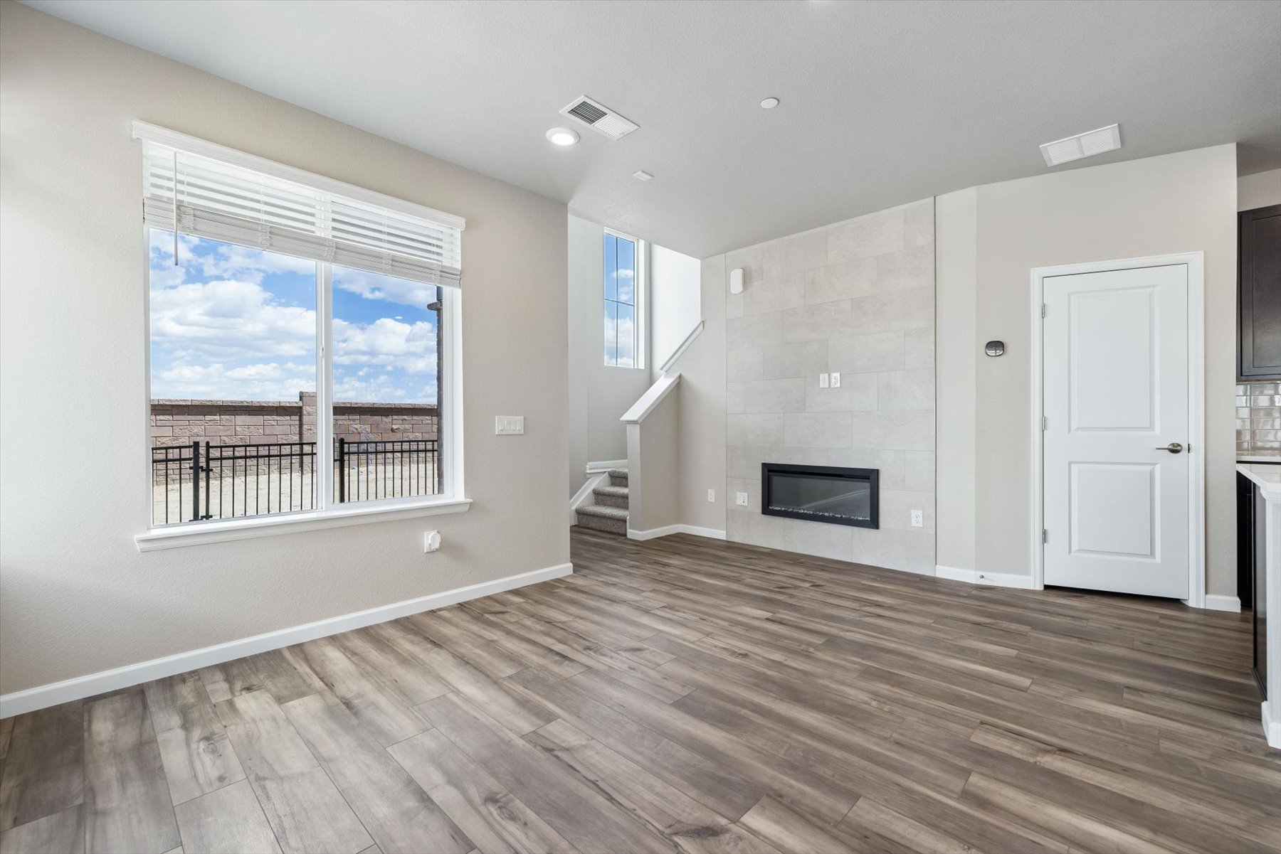 A room with a wood floor and a wood floor with a fireplace.