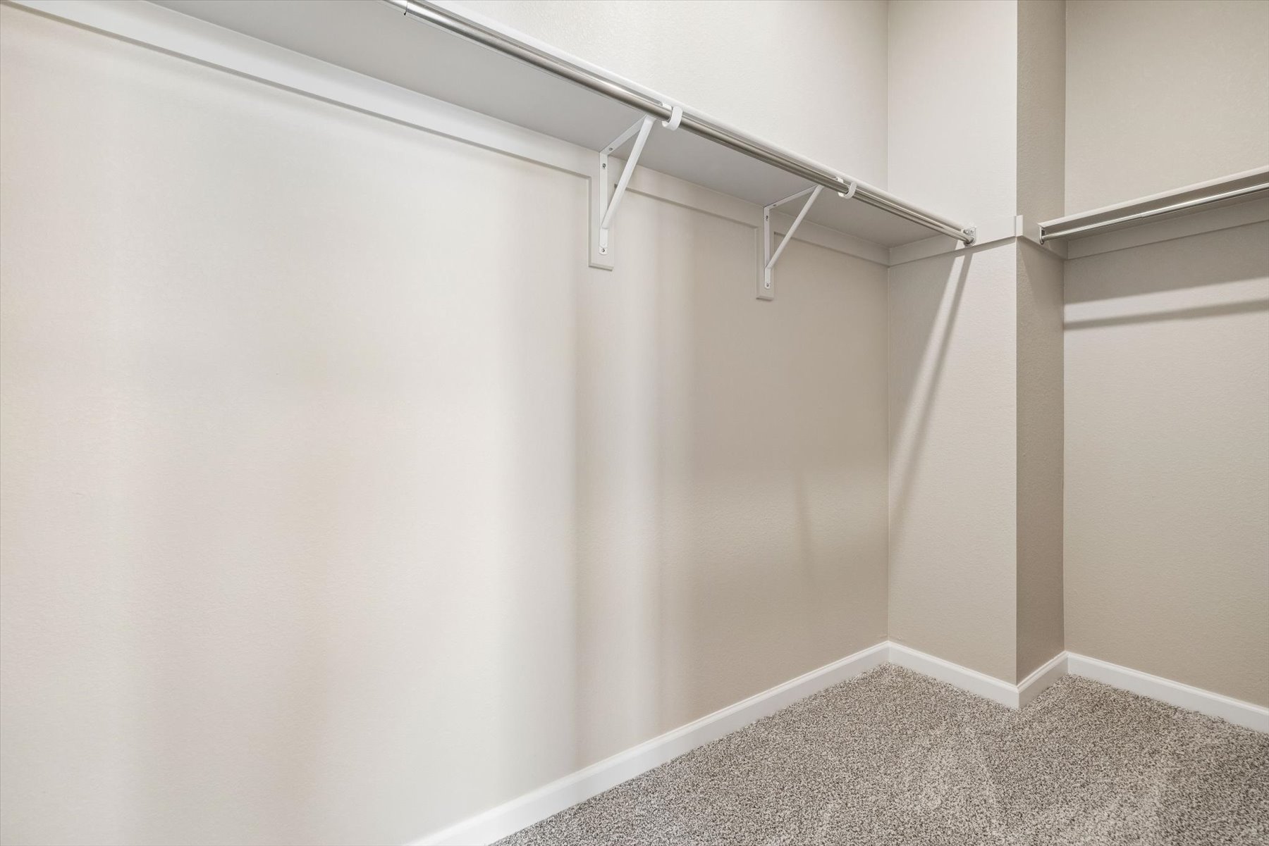 A white wall with a metal bar.