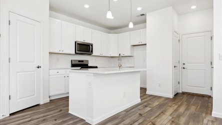 A kitchen with white cabinets.