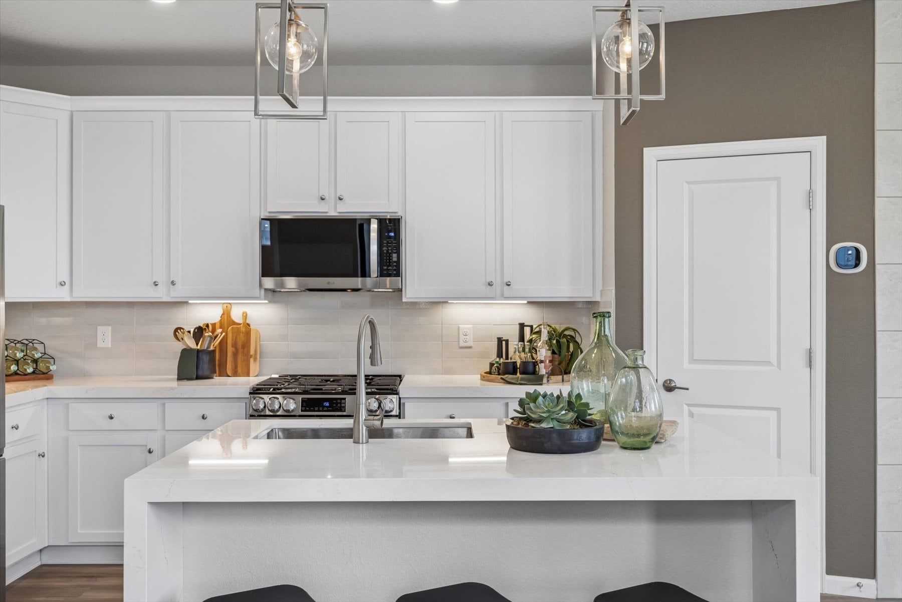 A kitchen with white cabinets.