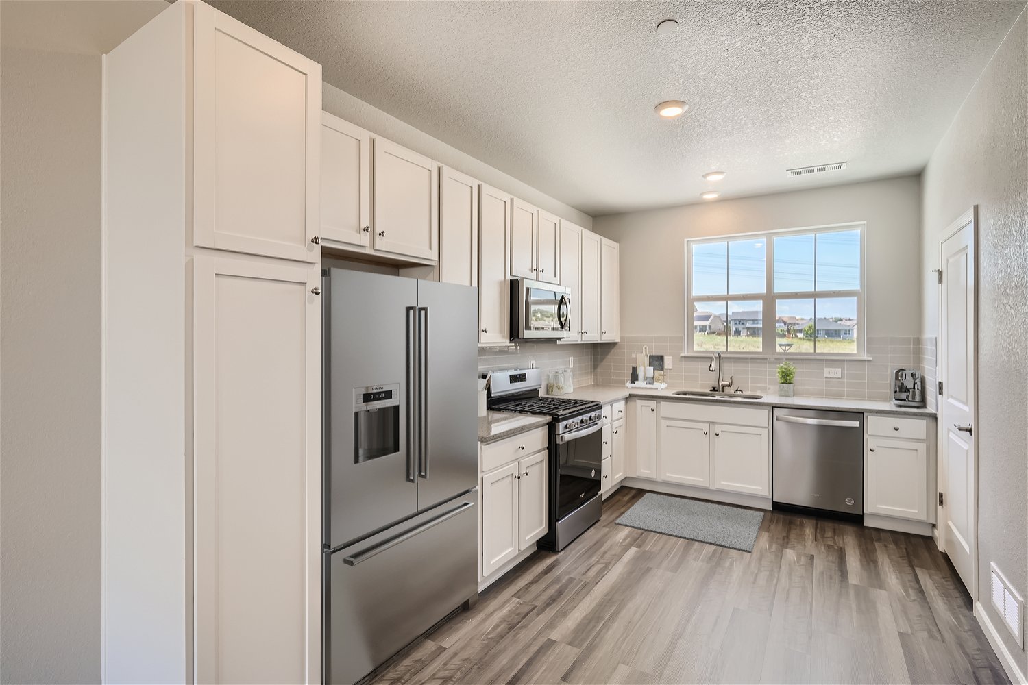 A kitchen with white cabinets.