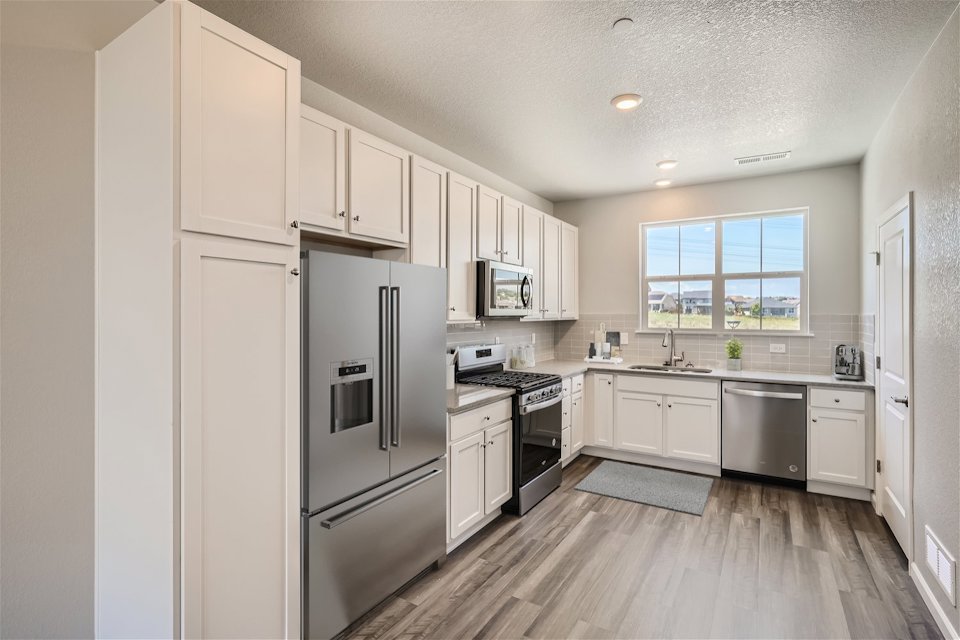 A kitchen with white cabinets.