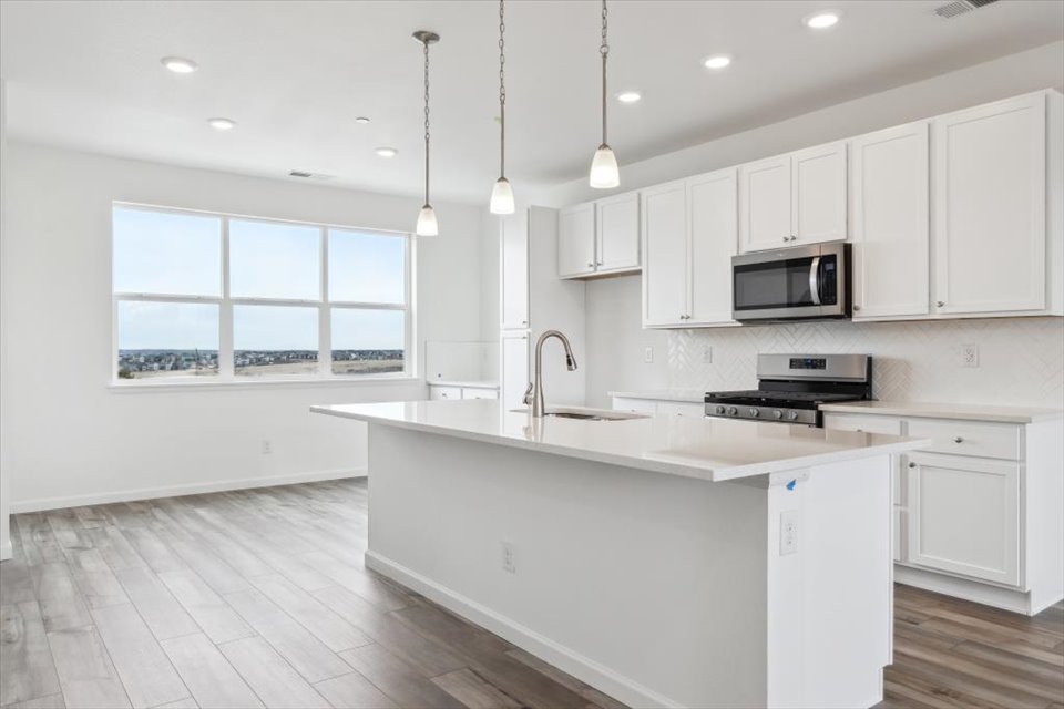 A kitchen with white cabinets.