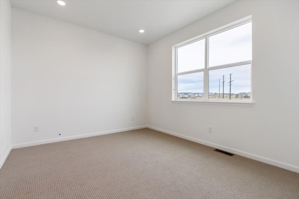 A room with a window and a carpet.