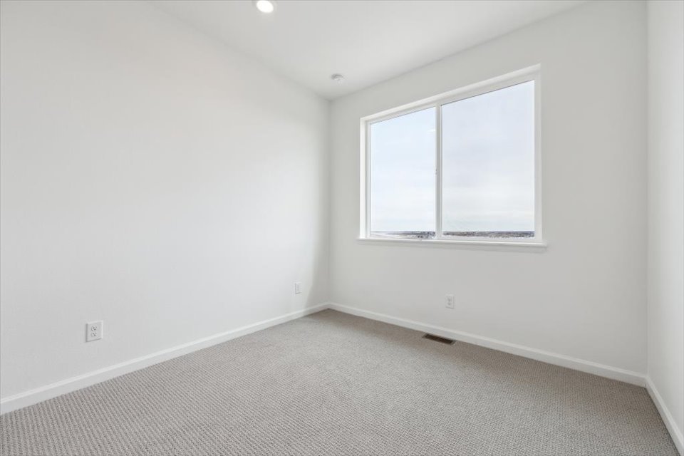 A room with a window and a carpet.