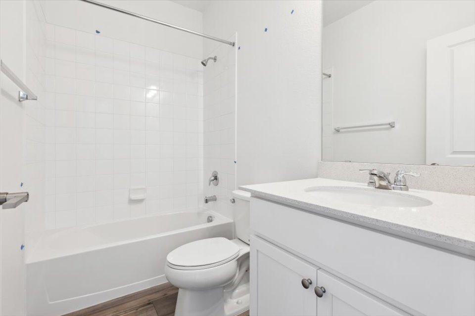 A bathroom with a tub sink and toilet.