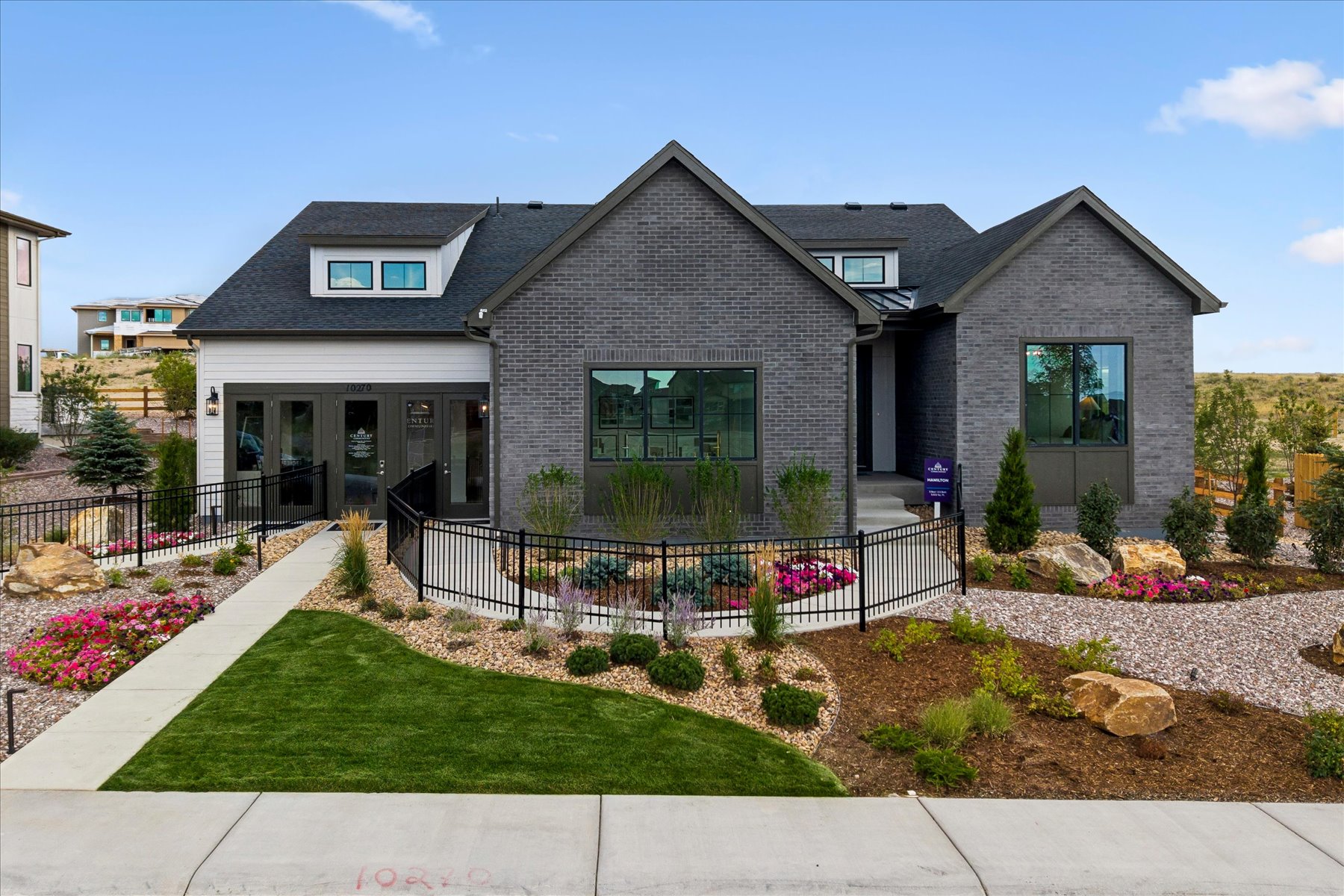 A house with a fence and a yard with a flower bed.