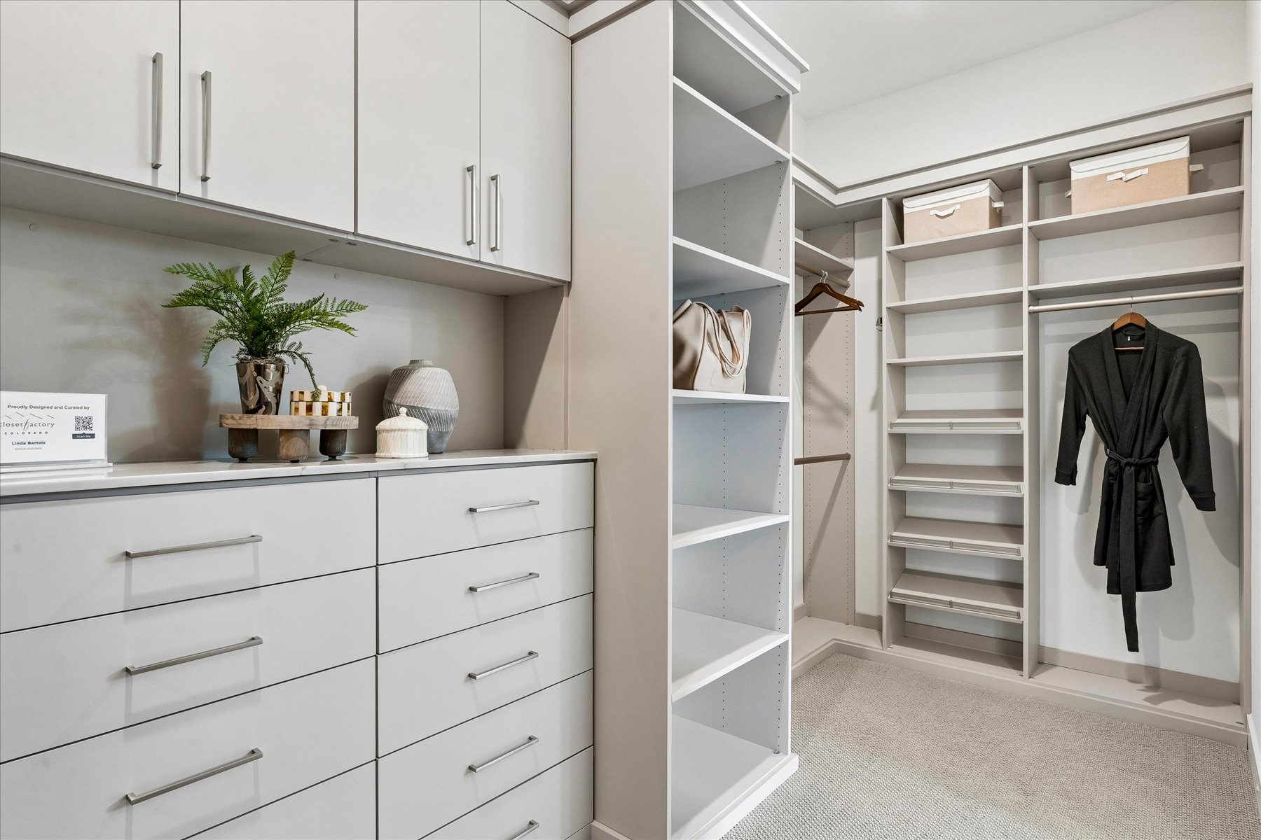 A white cabinet with a black coat on it.