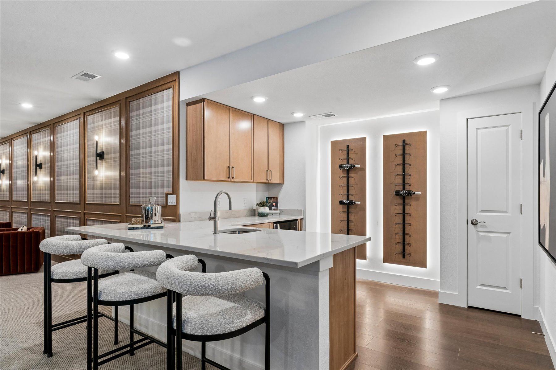 A kitchen with a bar and chairs.