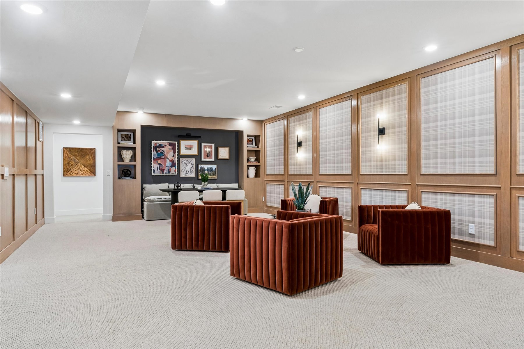 A room with a large wall of pictures and a large rug.