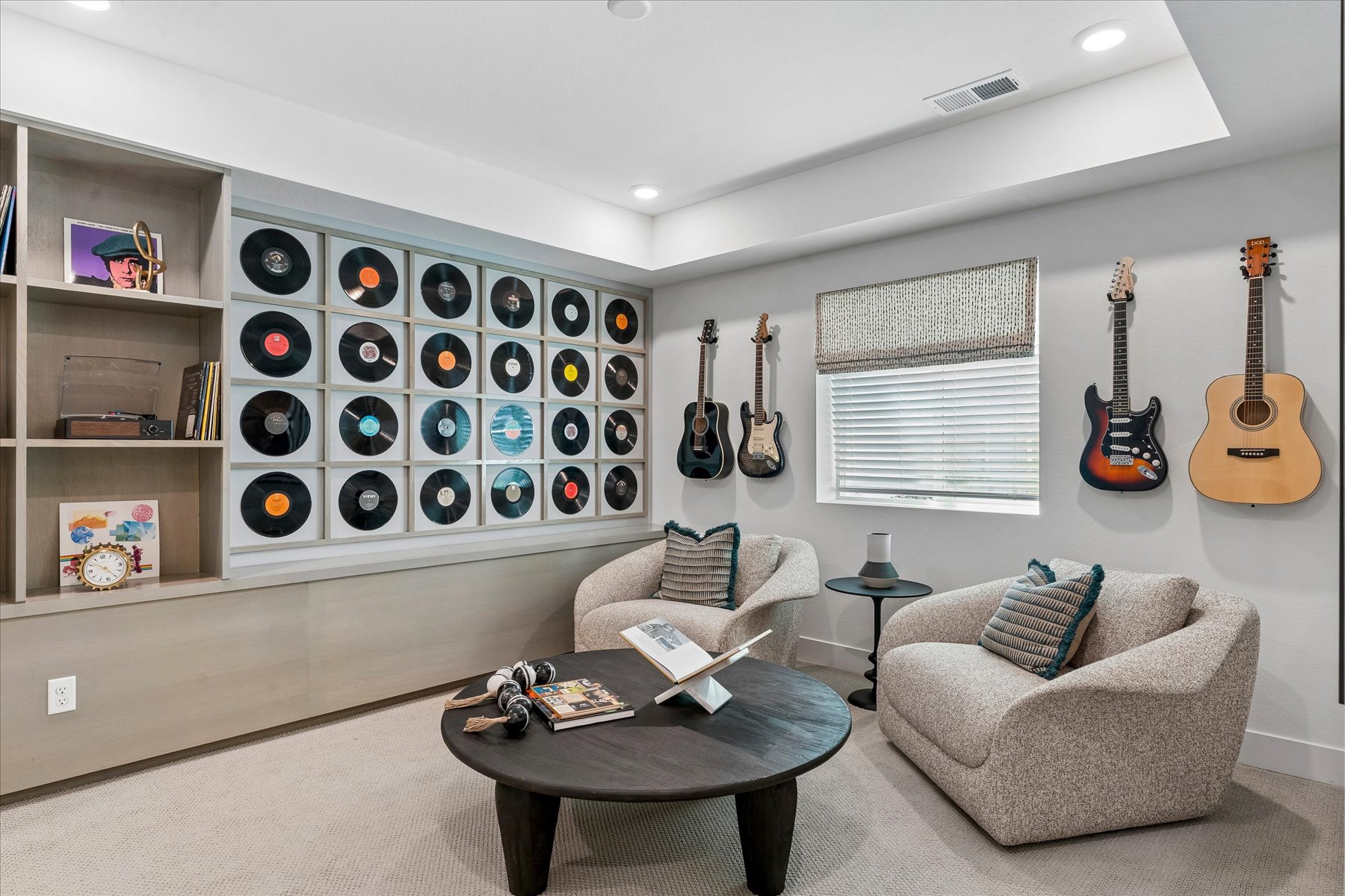 A room with a couch and shelves with guitars.