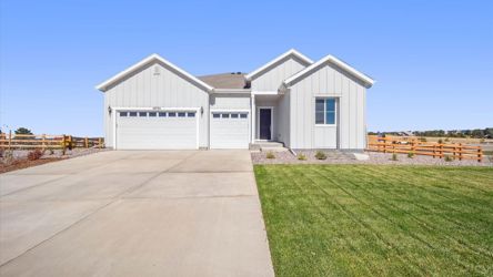 A white house with a green lawn.