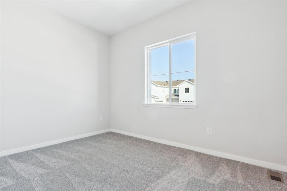 A room with a window and a carpet.
