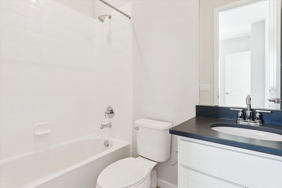A bathroom with a tub sink and toilet.