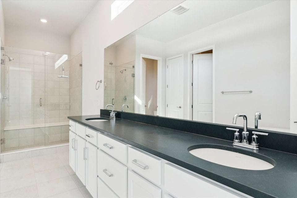 A bathroom with a sink and a shower unit.